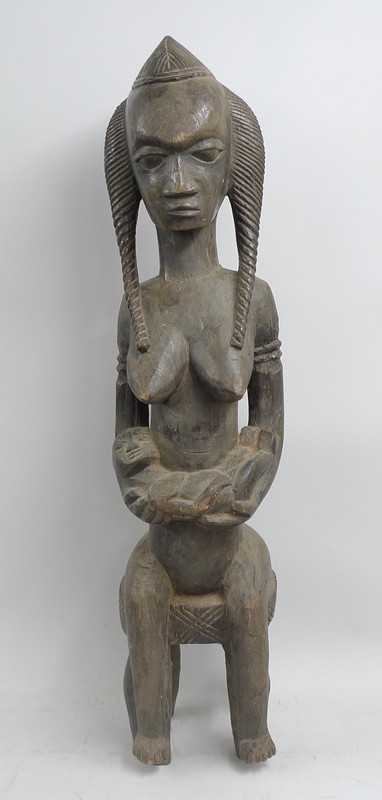 Ethnographic / Tribal: a carved wooden Baoule Mali maternity figure of a seated woman holding a