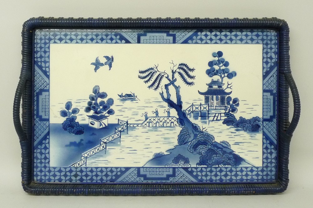 A Willow pattern pottery tray, made in Germany, early 20th century, with painted wicker handles