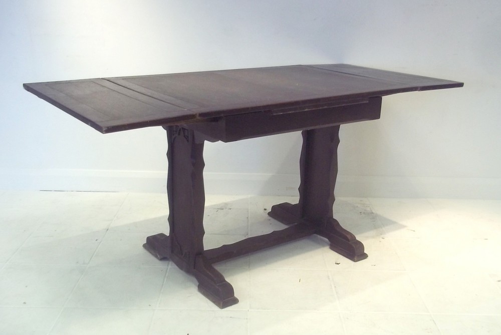An oak 1930s drawer leaf table in ecclesiastical design, 106 (166 extended) by 76 by 76cm high.