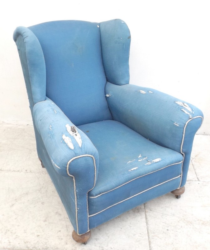A 1940's beech framed armchair, upholstered in blue fabric with white piping, raised on bun feet and