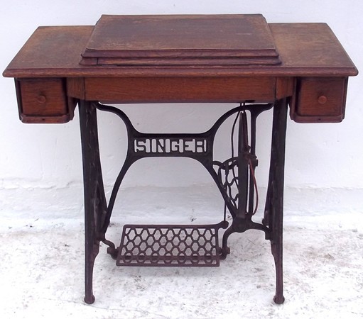 An oak treadle sewing machine containing a singer machine.