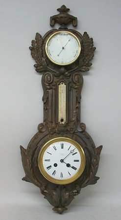 A Victorian cast iron wheel barometer by J J Wainwright and Co, Birmingham, with clock movement