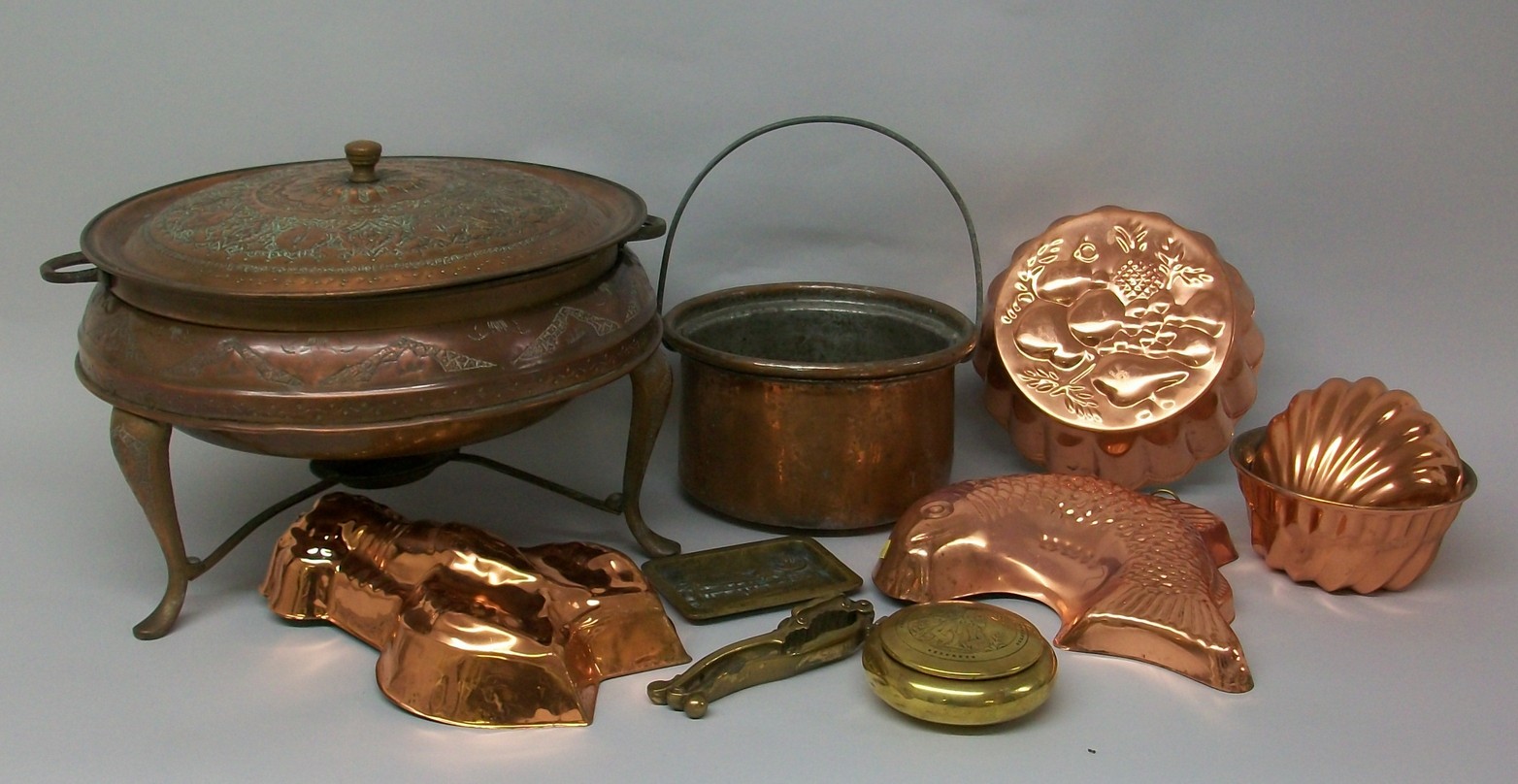 An Islamic copper embossed pot with burner, seven copper jelly moulds, a circular lidded pot, and