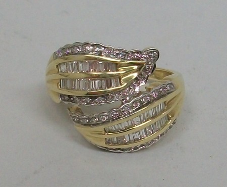 A 9ct gold and diamond set ring in a crossover leaf design, set with baguette and brilliant cut