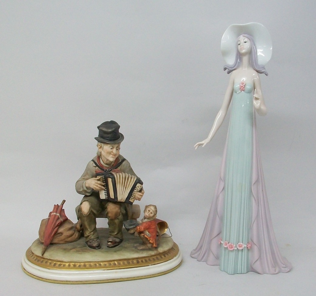 A Lladro porcelain figure modelled as a lady in a summer hat, number 1431, 35cm high, and a Capo