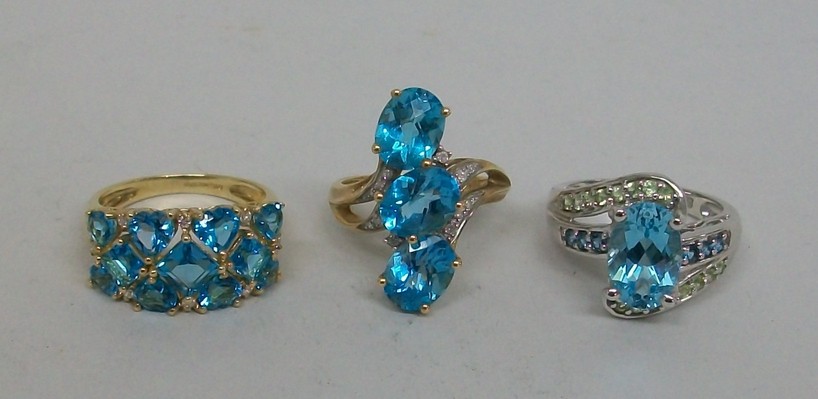 A 9ct gold and oval cut topaz three stone ring, size O, further 9ct gold and topaz set three