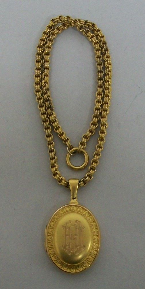 A Regency burnished gold oval hair locket, later monogram engraved front and back, the front