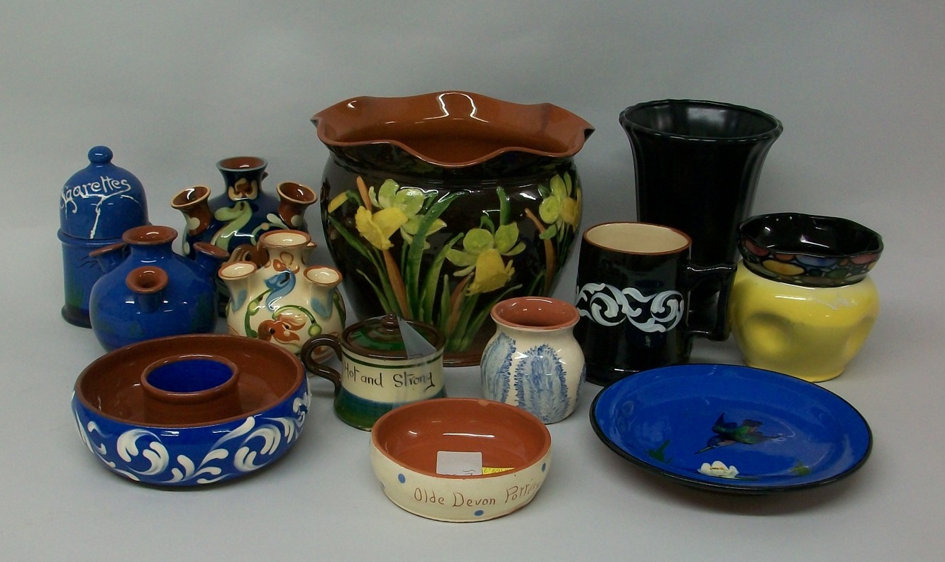 A quantity of Devon pottery including a jardiniere painted with daffodils, three quintel vases, a