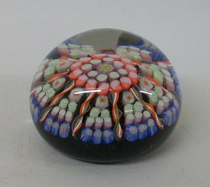 A glass millefiori four concentric ring paperweight, interspersed with spiral twist canes, 7cm