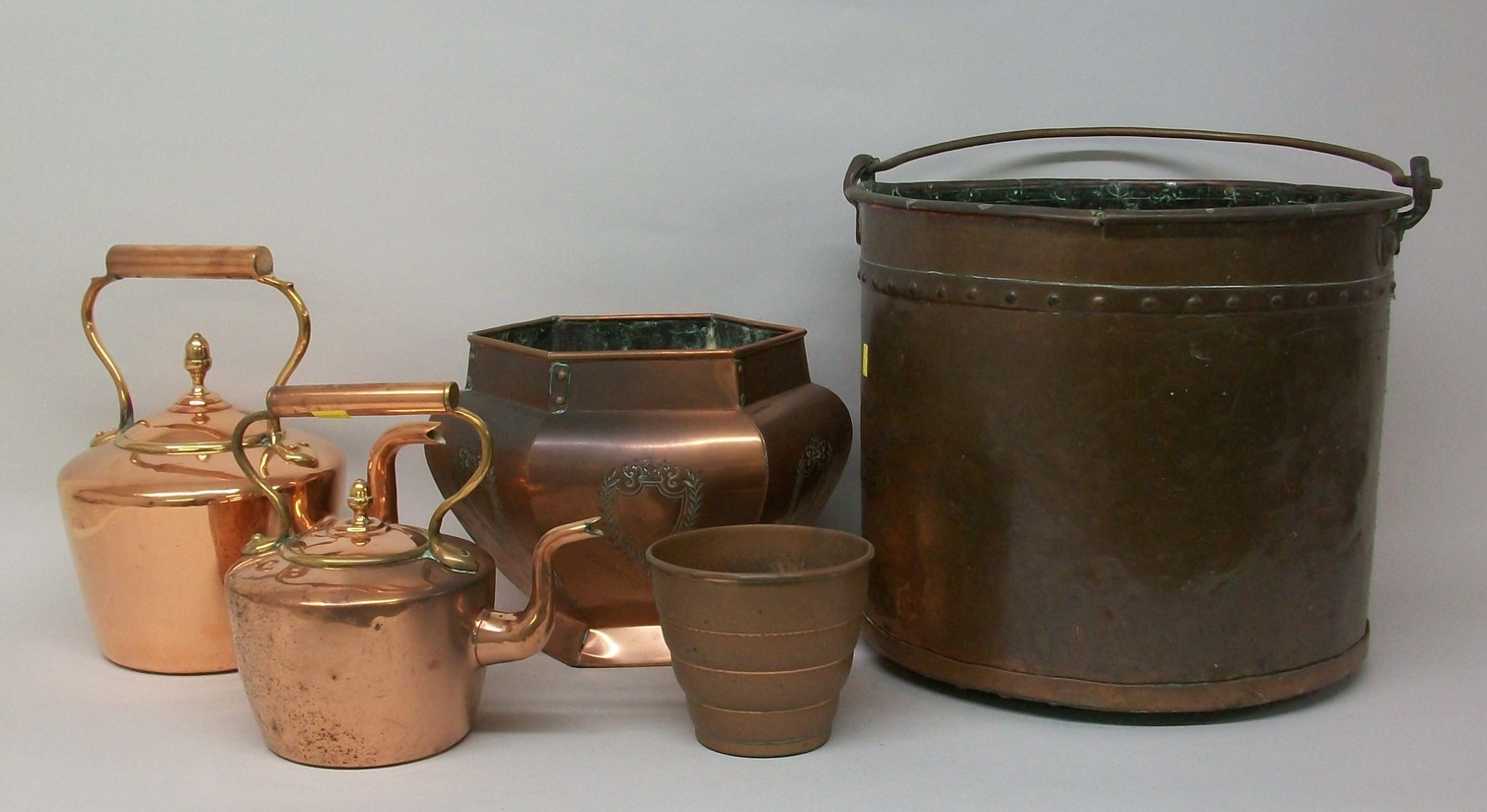 A copper coal bucket, marked 1847, 30 by 37cm diameter, two copper kettles and two planters. (5)