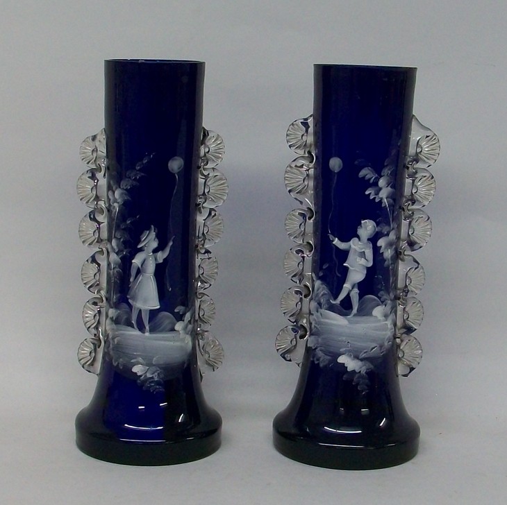 A pair of Mary Gregory style blue glass vases of cylindrical form with clear ribbed handles, painted