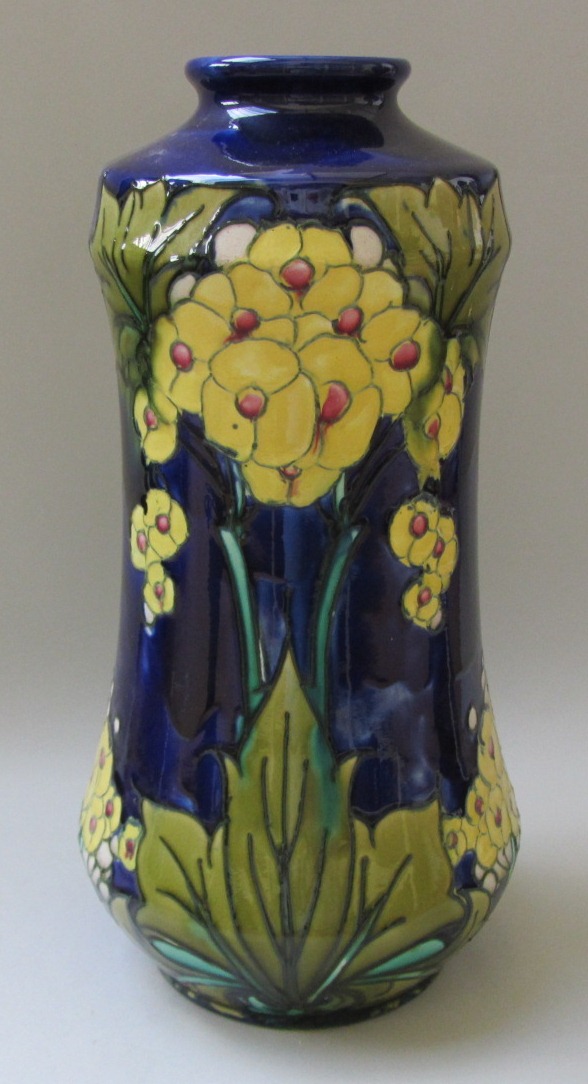 A Mintons Ltd vase, decorated with tube lined flowers against a cobalt blue ground, black printed