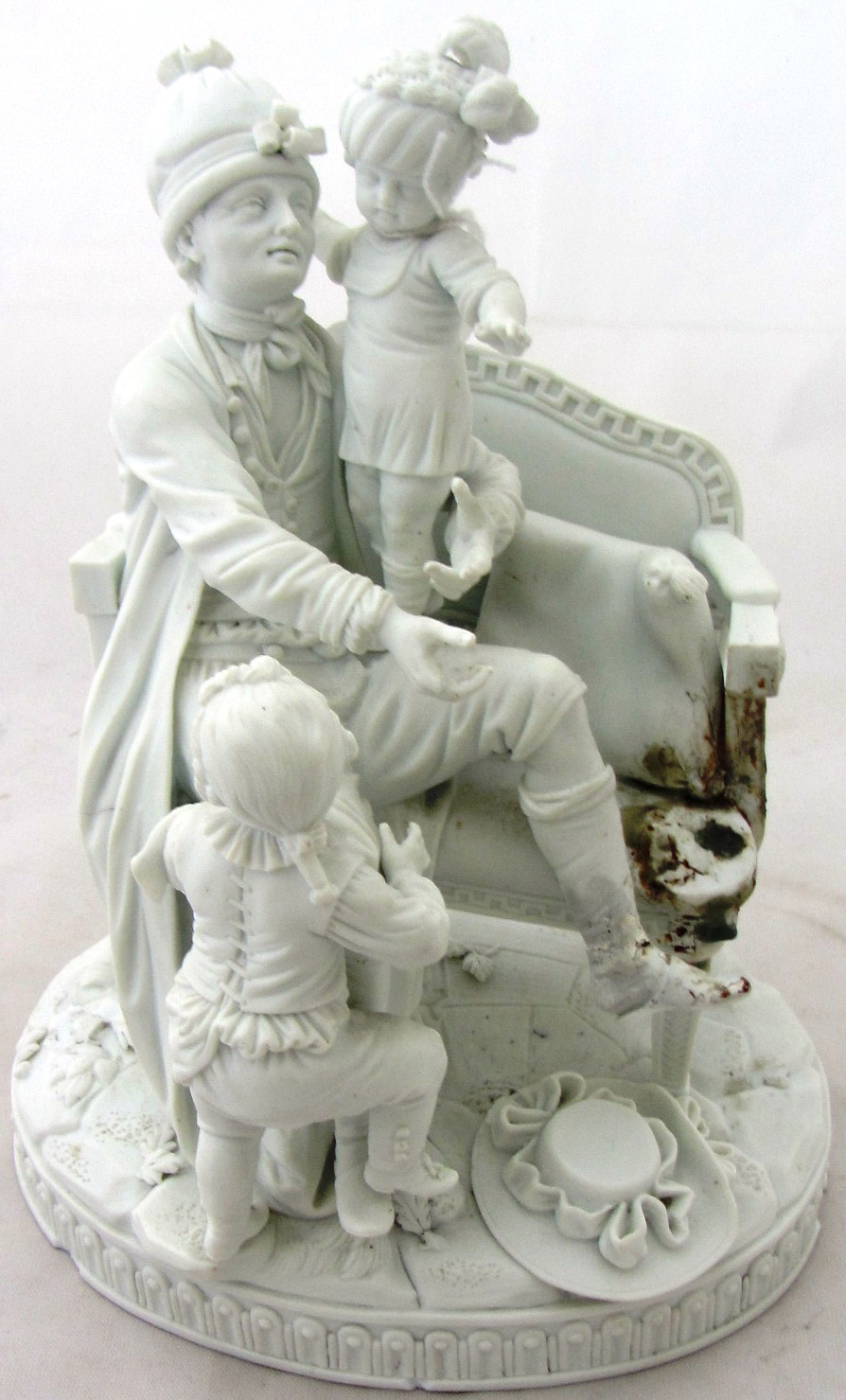 A Meissen biscuit porcelain group of a seated man and three children, early 19th century, incised