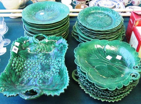 A composite group of green pottery dessert plates moulded with vine leaves, including a comport.