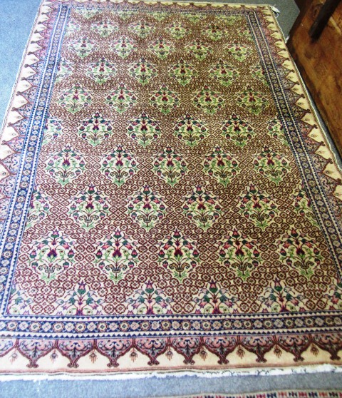 A Hereke rug, Turkey, the flower filled ivory field with rows of single flowering plants, an