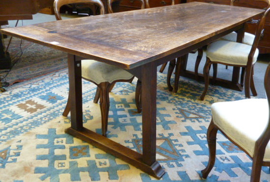 An early 20th century oak refectory table, raised on square supports bearing makers disk for