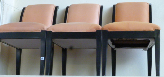 A set of twelve 20th century ebonised dining chairs, raised on sabre supports.