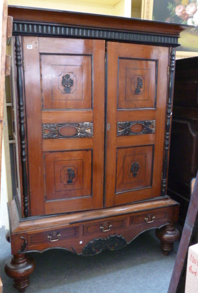 A 19th century Ceylonese hardwood and ebony banded cupboard, raised on turned supports, 142cm wide.