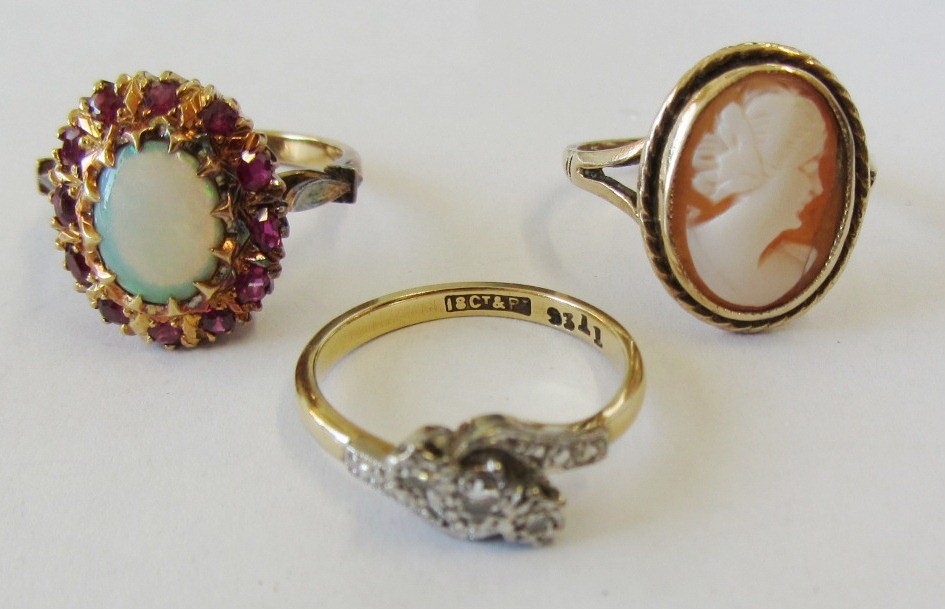 A gold, ruby and opal set oval cluster ring, mounted with the oval opal at the centre, within a