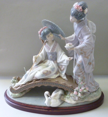 A Lladro porcelain figure group, No 1. 445, modelled with two Japanese ladies above a bridge, on a