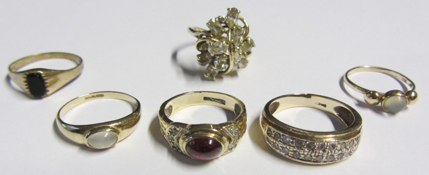 A 14ct gold and colourless gem set cluster ring, a 9ct gold ring mounted with an oval carbuncle