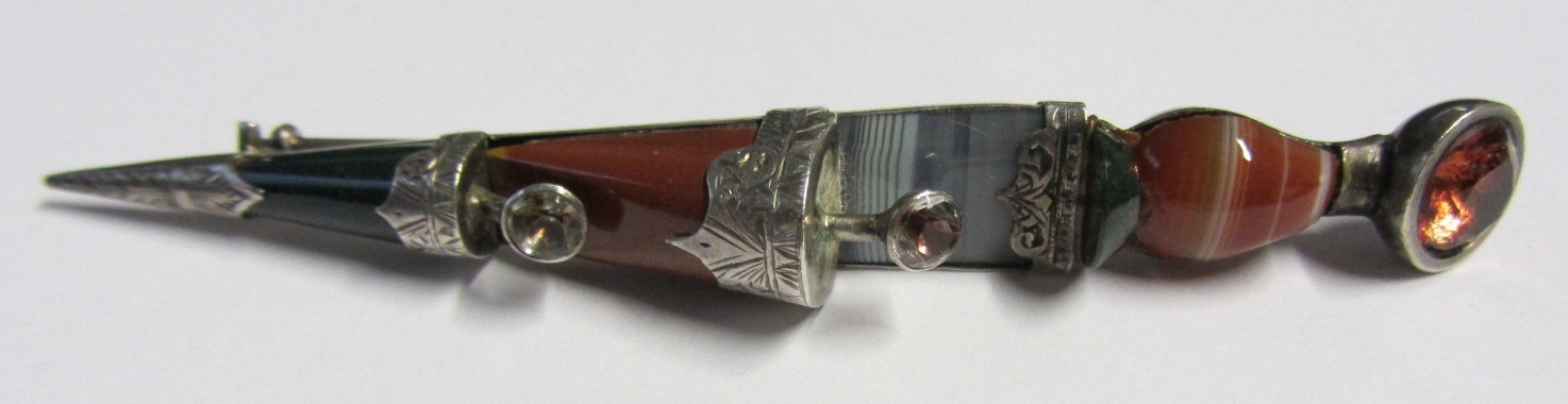 A foil backed gem set and vary coloured agate set brooch, designed as a Scottish skien d`hu,