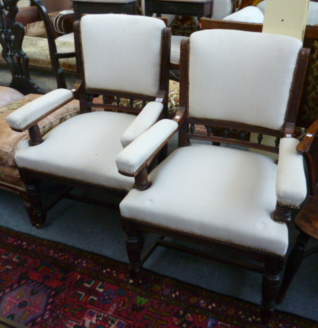 A pair of late Victorian oak open armchairs, on turned supports.