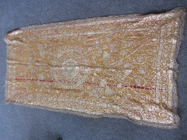 A Tunisian wedding shawl, circa 1900, the mustard yellow ground embroidered in hammered gilt, with a