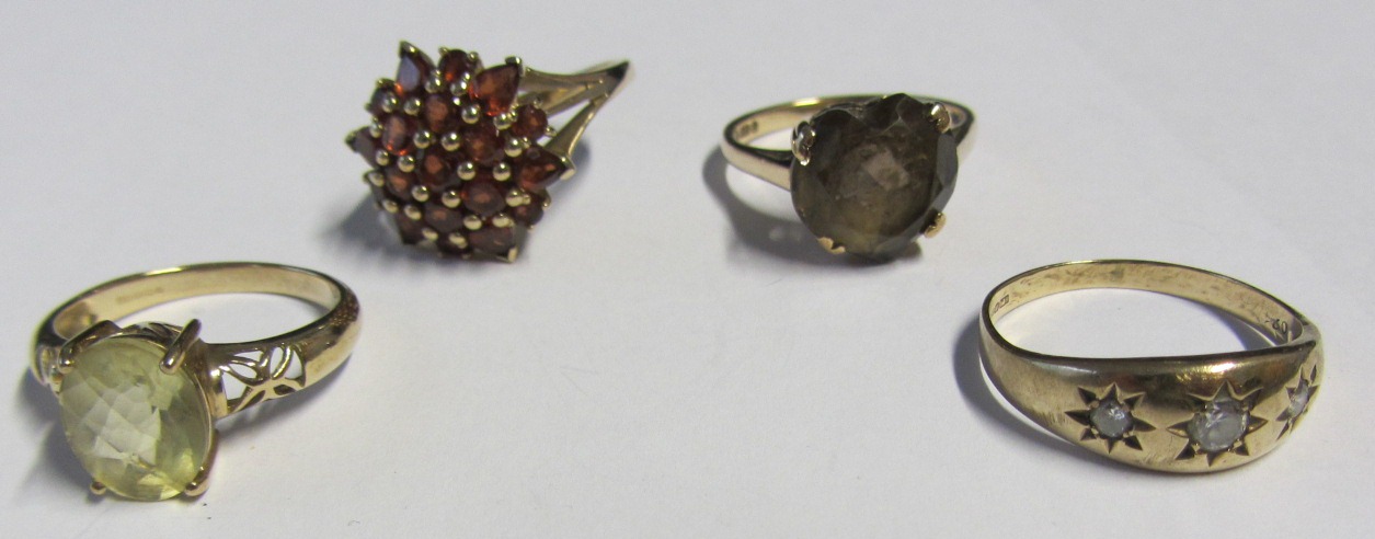 A 9ct gold and garnet set cluster ring, a 9ct gold ring, claw set with a heart shaped smoky quartz