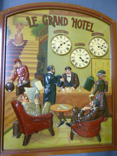 'Le Grand Hotel' advertising board with 3D carved figures and clocks showing times for London, Paris