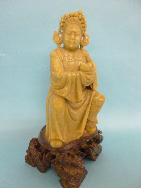19th century carved soapstone figure of a seated deity, on carved stone base, 18.5cms in height