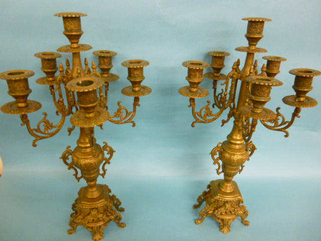 A pair of late 19th Century brass six branch candelabra each decorated with foliate and mask