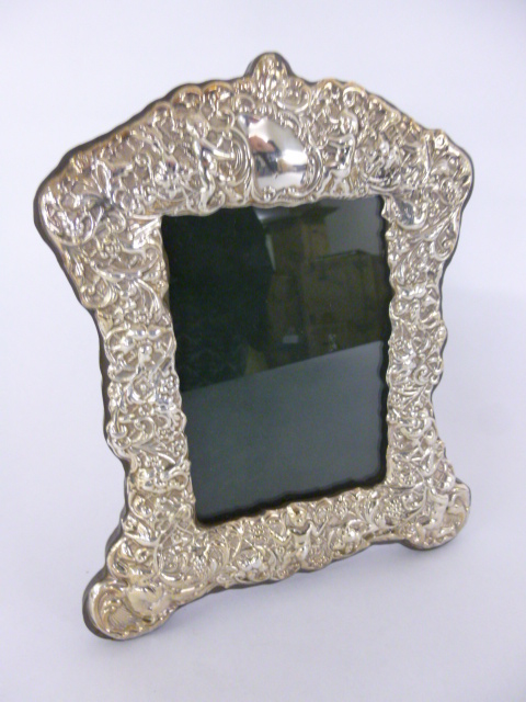 Silver photograph frame with embossed putti decoration, hallmarked Birmingham 2000, 17.5x21cms