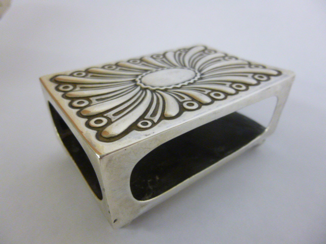 Large silver match box holder with embossed decoration and vacant cartouche on four ball feet,