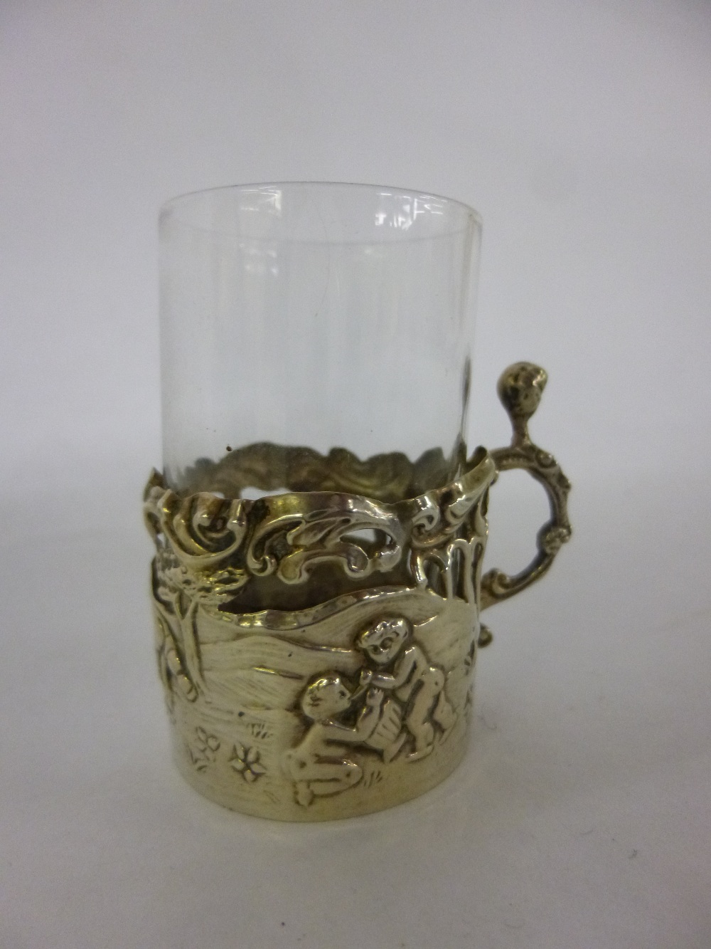 Miniature Silver cased tot glass, embossed with figures of playing children, star cut base to glass,