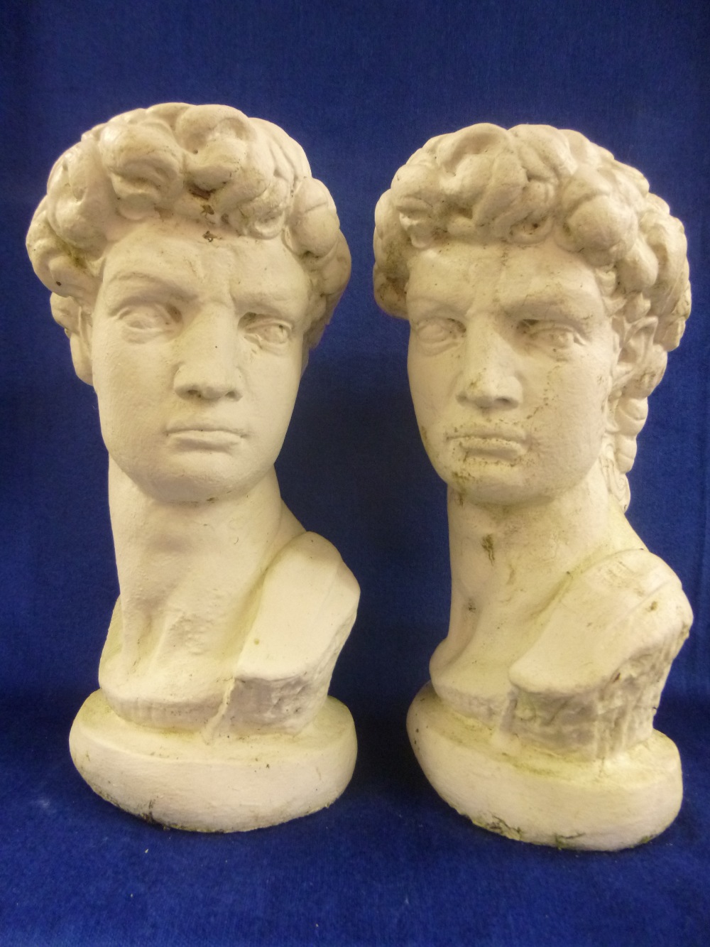 Two garden/gate post figure heads, each approx 34cms in height