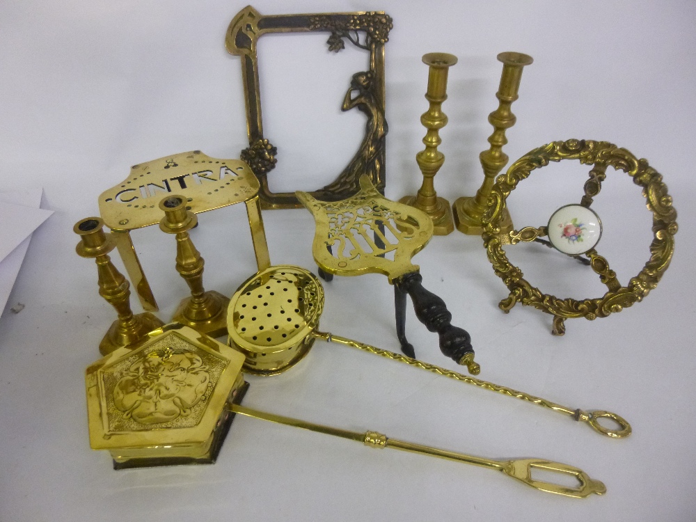 Assortment of brass items to include two pairs of candlesticks, two trivets, warmers and an Art