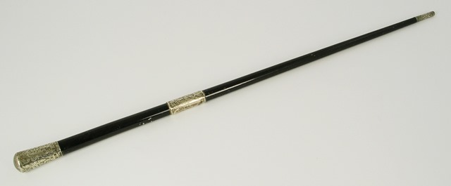 **N** AN EDWARDIAN SILVER MOUNTED EBONISED CONDUCTOR`S BATON having bright cut floral decorated cap,