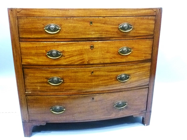 A 19TH CENTURY BOW FRONT MAHOGANY CHEST having triple plain top over four graduated long drawers,