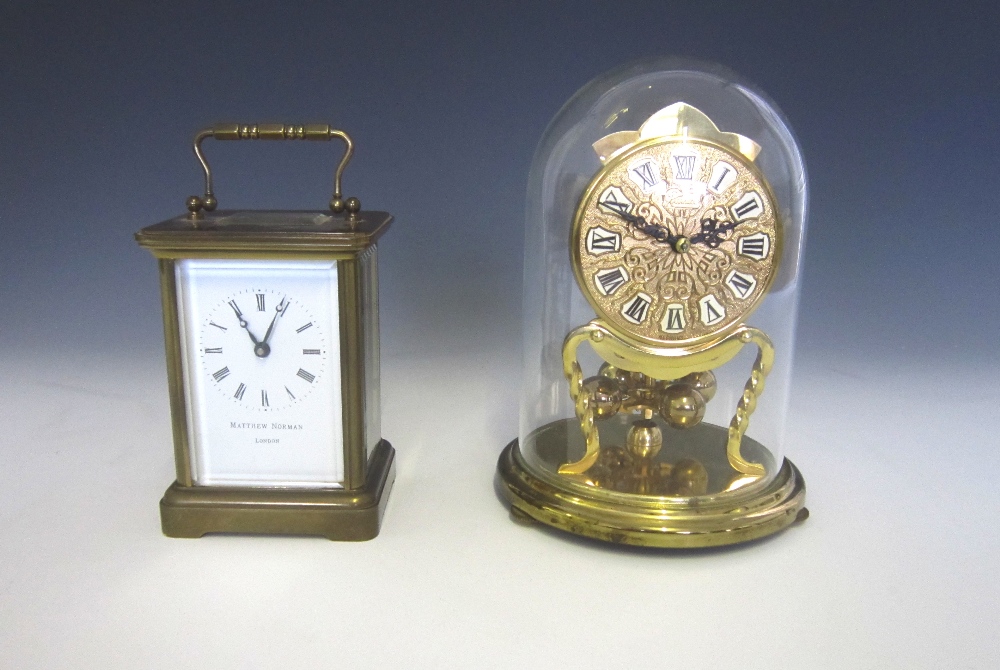 A brass carriage clock with Roman enamelled dial by Mathew Norman London on plinth base 11cm high