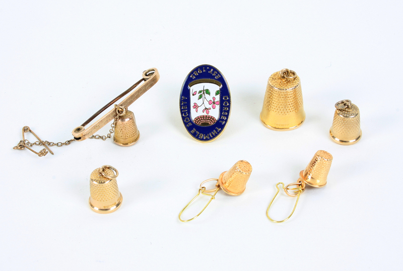 Thimble Jewellery: Comprising; three 9ct gold thimble charms, a pair of thimble earrings, a gold