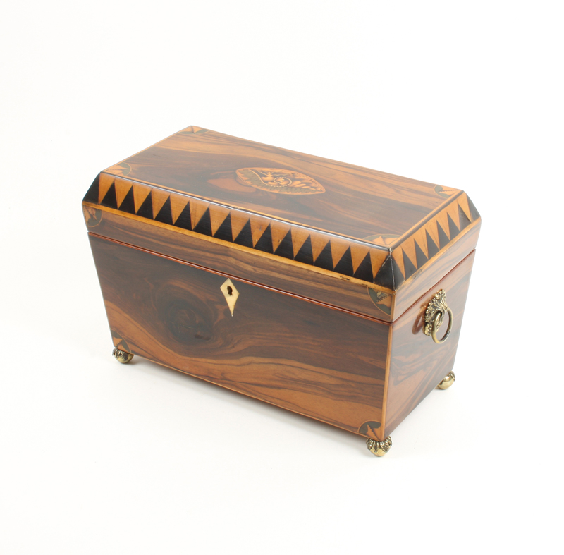 A Regency roseewood tea caddy of sarcophagus form, the lid centred by a shell inlaid oval with