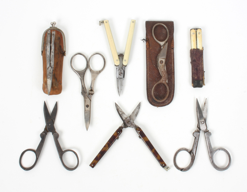 Eight pairs of folding scissors, including a pair with pivoting handles, two pairs of folding arm