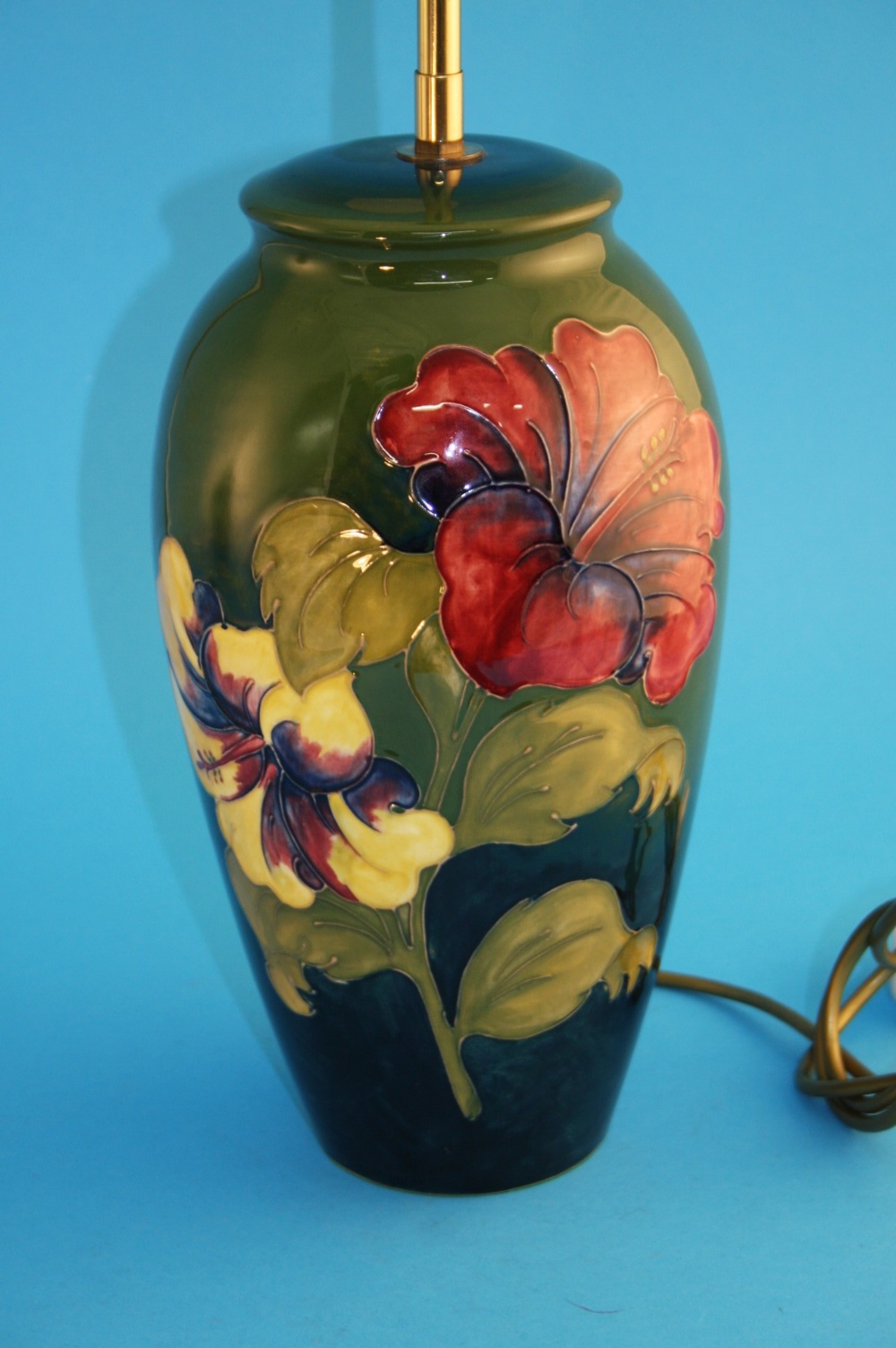 A tall modern Moorcroft baluster shaped "Hibiscus" pattern table lamp on a graduating green