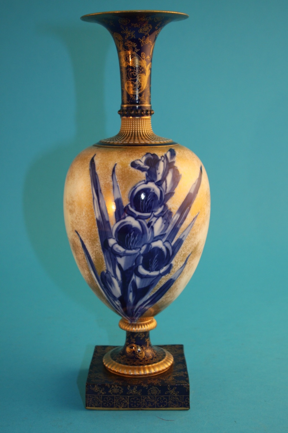 A Doulton Burslem vase with trumpet shaped top, ovoid body decorated with blue flowers highlighted