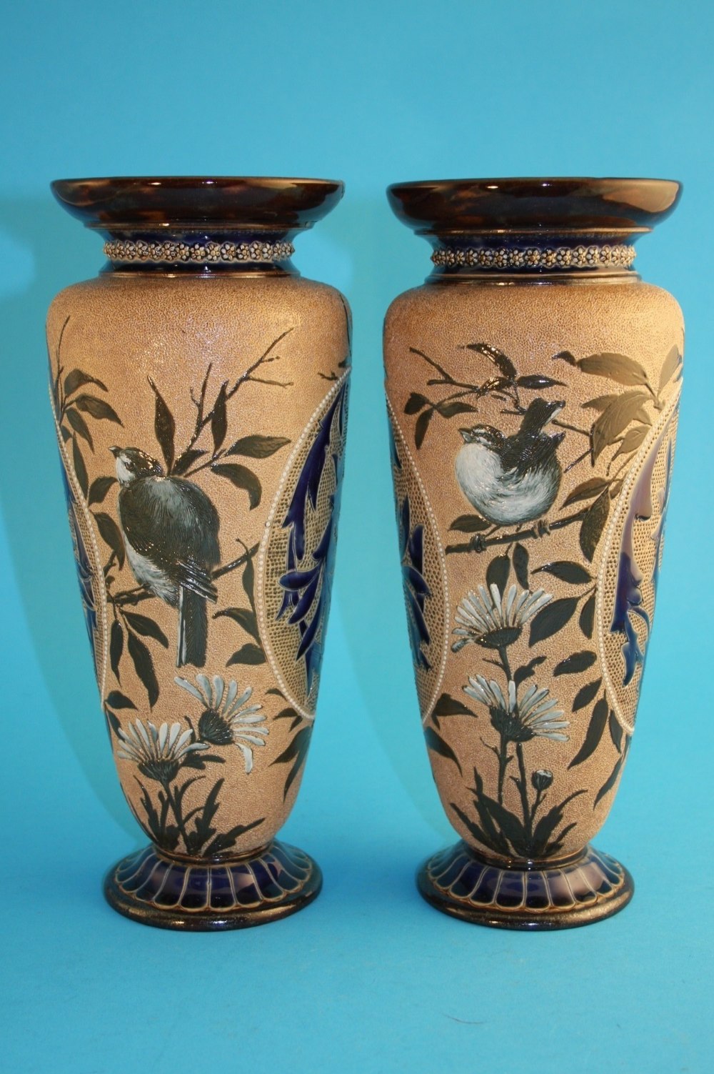 A tall pair of Doulton Lambeth stoneware vases by Florence Barlow, decorated with pate-sur-pate