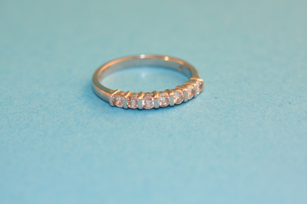 A half hoop eternity ring set with seven diamonds.