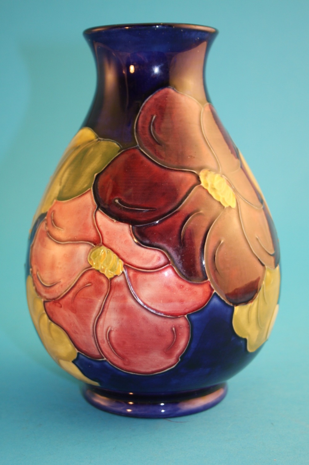 A Moorcroft baluster shaped vase "Hibiscus" pattern on a dark blue ground, labelled and impressed