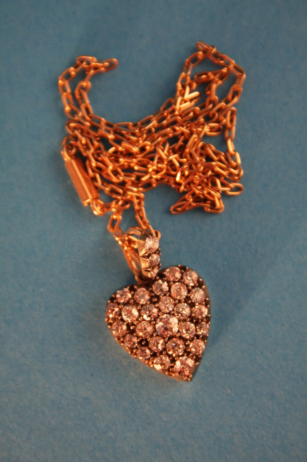 A heart shaped gold and diamond encrusted pendant set with a total of 28 diamonds.