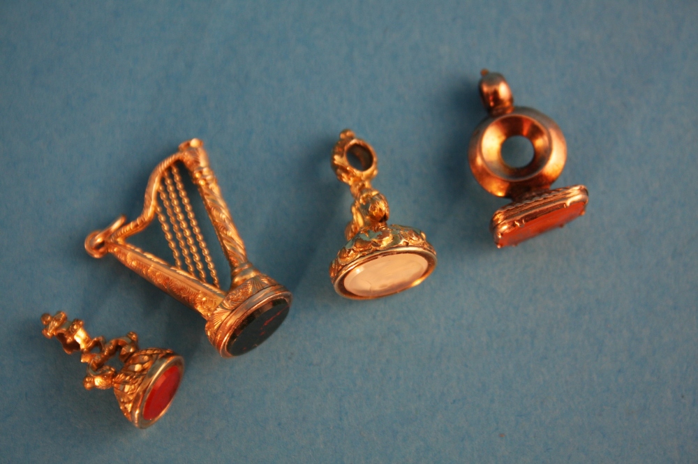 Four 9ct gold stone set miniature seals.